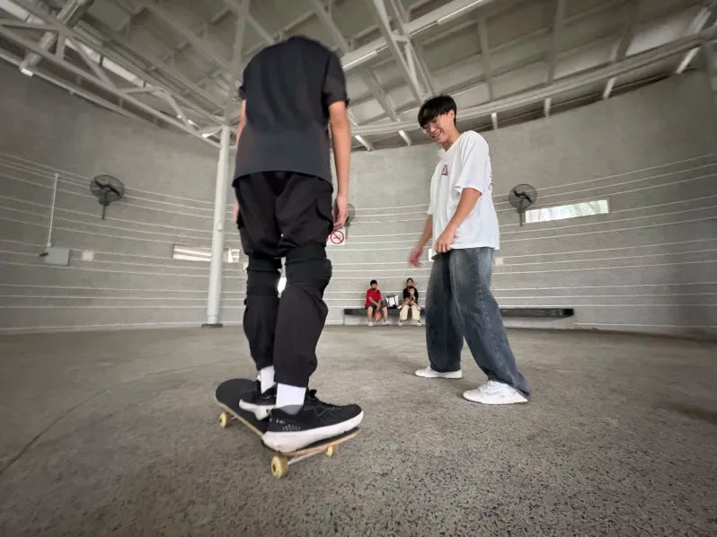 A coach guiding a rider through a skateboard attempt
